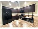 Well-equipped kitchen featuring dark cabinetry, stainless steel appliances, and modern countertops at 22755 W Yavapai St, Buckeye, AZ 85326