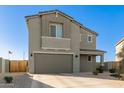 This two-story home features a neutral facade, well-maintained desert landscaping, and an attached two-car garage at 22962 N 182Nd Ln, Surprise, AZ 85387