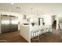 Bright and modern kitchen featuring a large island with seating, stainless steel appliances, and elegant countertops at 3413 N 87Th Pl, Scottsdale, AZ 85251