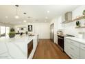 Open-concept kitchen showcasing a large island with stainless steel appliances and hardwood floors, creating a warm atmosphere at 3413 N 87Th Pl, Scottsdale, AZ 85251