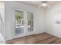 Bright living area featuring wood floors, ceiling fan, and double doors to the outside at 3511 E Baseline Rd # 1235, Phoenix, AZ 85042