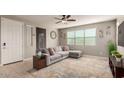 Comfortable living room featuring a ceiling fan, large window, and neutral decor at 3914 S 58Th Ln, Phoenix, AZ 85043