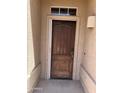 Covered front door with dark wood finish, transom window, and traditional hardware at 4016 E Western Star Blvd, Phoenix, AZ 85044