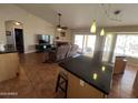Open-concept living room and kitchen area with tile floors, fireplace, and sliding glass doors to the outdoors at 4016 E Western Star Blvd, Phoenix, AZ 85044