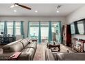 Bright living room featuring a large leather couch, hardwood floors, and sliding glass doors to the backyard at 4044 E Dawson E Dr, Chandler, AZ 85249