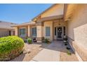 Inviting front entrance with decorative door, covered porch, desert landscaping and walkway at 4349 W Cielo Grande --, Glendale, AZ 85310