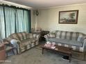 Cozy living room featuring comfortable plaid sofas and a vintage aesthetic at 4410 N 50Th Dr, Phoenix, AZ 85031