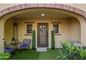 Inviting front porch with decorative door, lush greenery, a cozy seating area, and stylish decor accents at 4419 N 24Th Way, Phoenix, AZ 85016