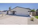 View of the two-car garage and low-maintenance landscaping of this single-story home at 4509 E La Puente Ave, Phoenix, AZ 85044