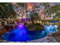 Spectacular outdoor pool area with waterfall, lush landscaping, and private cabana at 6112 E Jenan Dr, Scottsdale, AZ 85254