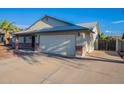 Home exterior highlighting the two-car garage and side yard, with a well-kept driveway and desert landscaping at 6311 E Ivy St, Mesa, AZ 85205