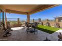 Inviting covered patio with outdoor seating and artificial turf for low-maintenance relaxation at 6912 E Quill St, Mesa, AZ 85207