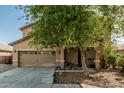 Attractive home featuring a two-car garage, covered entry, and desert-friendly landscaping at 7090 S 252 Dr, Buckeye, AZ 85326