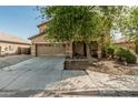 Beautiful home exterior showcasing a two-car garage, long driveway, and covered porch at 7090 S 252 Dr, Buckeye, AZ 85326