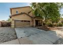 Inviting home exterior with a two-car garage, covered entry, and mature landscaping at 7090 S 252 Dr, Buckeye, AZ 85326
