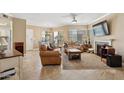 Bright living room featuring tile floors, a ceiling fan, a fireplace, and comfortable seating at 7575 E Indian Bend Rd # 1137, Scottsdale, AZ 85250