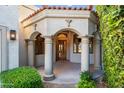 Grand entrance featuring stately columns, arched entryways, and a beautiful wooden door at 8429 E Del Camino Dr, Scottsdale, AZ 85258