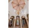 Elegant foyer showcasing a high ceiling with a unique wooden design, arched doorways, and a view of the entryway at 8429 E Del Camino Dr, Scottsdale, AZ 85258