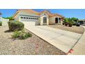 Inviting single-story home with two car garage, long driveway, and desert landscaping at 8854 W Augusta Ave, Glendale, AZ 85305