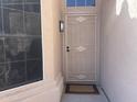 Inviting entryway with a decorative security screen door and modern outdoor lighting fixture at 9853 W Pontiac Dr, Peoria, AZ 85382