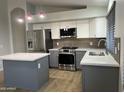Stylish kitchen with stainless steel appliances, an island, and sleek countertops at 9853 W Pontiac Dr, Peoria, AZ 85382