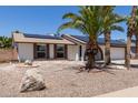 Inviting single-story home featuring solar panels, desert landscaping, and an arched entryway at 10610 W Diana Ave, Peoria, AZ 85345