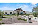 Beautiful home exterior with manicured lawn and desert rock landscaping at 10755 E Cholla Ln, Scottsdale, AZ 85259