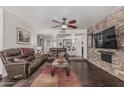 Inviting living room with a stone accent wall, fireplace, dark hardwood floors and comfortable leather furniture at 1121 W Mission Dr, Chandler, AZ 85224