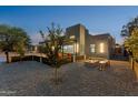 Beautiful backyard featuring a modern home, fire pit, decorative rock, and a covered patio seating area at 1211 E Hayward Ave, Phoenix, AZ 85020