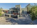 An expansive backyard with a covered patio, a gravel landscape, and block perimeter fencing at 1211 E Hayward Ave, Phoenix, AZ 85020