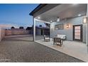 Covered outdoor patio with comfortable seating, ceiling fan and warm lighting, perfect for relaxation at 1211 E Hayward Ave, Phoenix, AZ 85020