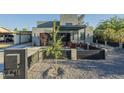 Modern home showcasing a covered patio, manicured landscaping, and zero landscape front yard at 1211 E Hayward Ave, Phoenix, AZ 85020