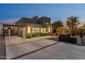 Stunning modern home featuring a sleek design, a spacious driveway, and an inviting outdoor seating area at 1211 E Hayward Ave, Phoenix, AZ 85020