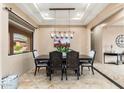 Bright dining room featuring stylish light fixture, tile floors, and an attractive desert scene painting at 13206 N 64Th St, Scottsdale, AZ 85254