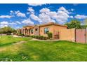 Home exterior with lush lawn, mature landscaping, brick privacy fence, and elegant architectural details at 13206 N 64Th St, Scottsdale, AZ 85254