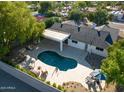 Aerial view showcases the backyard pool with fountains, a covered patio, and a well-maintained landscape with mature trees at 16227 N 63Rd Pl, Scottsdale, AZ 85254