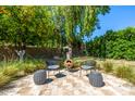 Cozy backyard with a fire pit, comfortable seating, and lush landscaping for relaxation and outdoor enjoyment at 16227 N 63Rd Pl, Scottsdale, AZ 85254