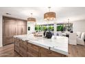 Large kitchen island with marble countertop, adjacent to the dining area and overlooking the backyard at 16227 N 63Rd Pl, Scottsdale, AZ 85254