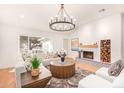 Inviting living room with a cozy fireplace, stylish decor, comfortable seating, and ample natural light from a large window at 16227 N 63Rd Pl, Scottsdale, AZ 85254