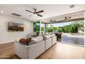 Bright living room with ceiling fan, large sectional, and an expansive view of the private backyard at 16227 N 63Rd Pl, Scottsdale, AZ 85254
