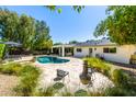 Inviting backyard oasis featuring a sparkling pool, brick patio, mature trees, and comfortable seating areas at 16227 N 63Rd Pl, Scottsdale, AZ 85254
