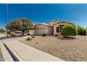 Charming single-story home featuring a two-car garage and desert landscaping at 20424 N 96Th Ln, Peoria, AZ 85382