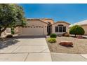 Charming single-story home featuring a two-car garage and desert landscaping at 20424 N 96Th Ln, Peoria, AZ 85382