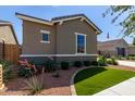 Beautiful home exterior with artificial turf, decorative rock, and mature landscaping at 21031 E Poco Calle St, Queen Creek, AZ 85142