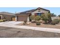 Single-story home with a two-car garage, low-maintenance front yard, and solar panels on the roof at 23730 W Hess Ave, Buckeye, AZ 85326