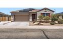 Inviting single-story home featuring a two-car garage, desert landscaping, and solar panels at 23730 W Hess Ave, Buckeye, AZ 85326