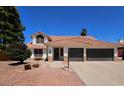 Charming home showcases a tile roof, well-manicured landscaping, and a spacious two-car garage at 2712 W Oakgrove Ln, Chandler, AZ 85224