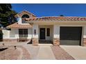 Inviting home exterior features a tile roof, landscaped front yard, and a convenient two-car garage at 2712 W Oakgrove Ln, Chandler, AZ 85224