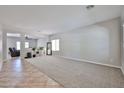 Spacious living room with tiled floors, neutral walls, an accent rug, and an adjacent den at 30263 W Crittenden Ln, Buckeye, AZ 85396