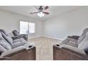 Home theatre showcasing luxurious seating, a ceiling fan, and large window at 30263 W Crittenden Ln, Buckeye, AZ 85396